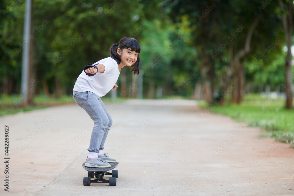 Cute little girl playing skateboard or surf skate in the skate park Cute little girl playing skateboard or surf skate in the skate park