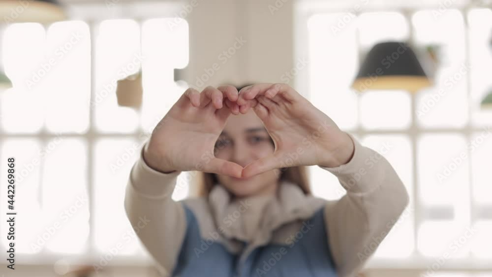 Pretty brunette making heart shape with fingers Pretty brunette making heart shape with fingers