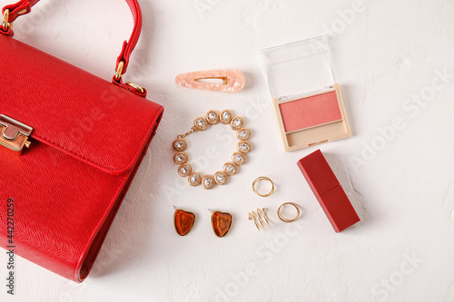 Set of female accessories with stylish bag on light background