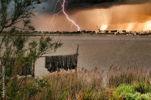 Un orage et la foudre au dessus de la ville d'Aigues Mortes dans le sud de la France photo