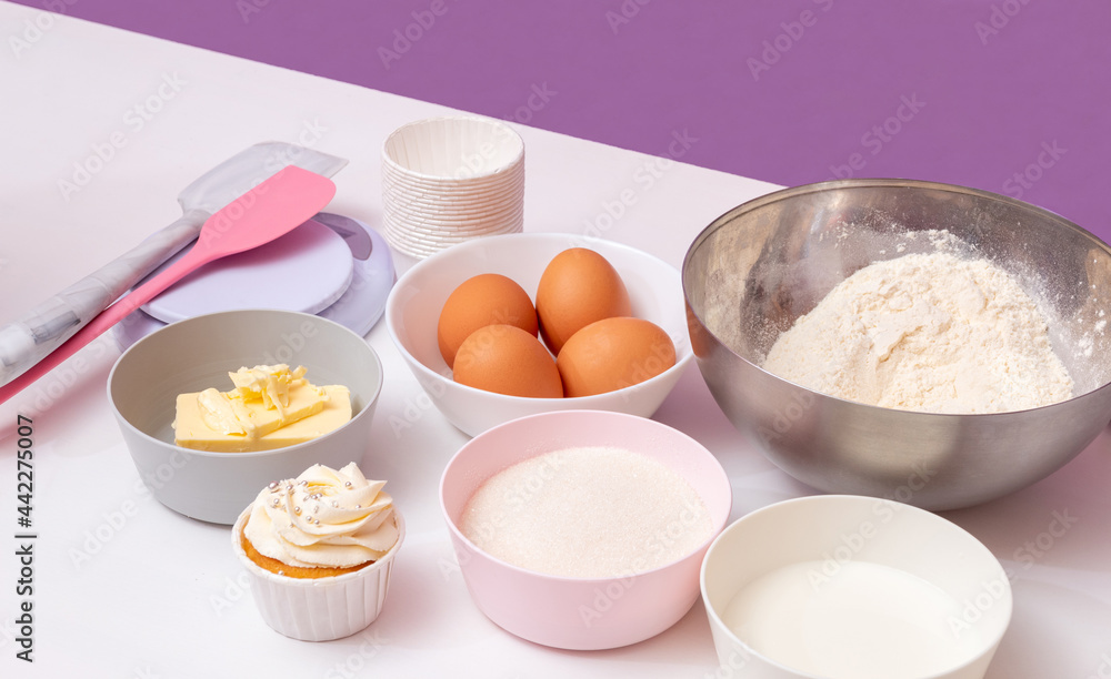 Cupcake and ingredients for its preparation on a white table. Selective focus. Cupcake and ingredients for its preparation on a white table. Selective focus.