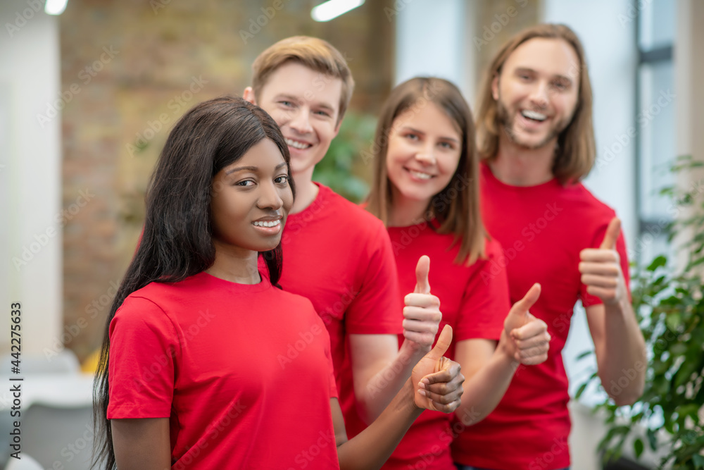 Fototapeta premium African american girl and friends volunteers showing ok gesture