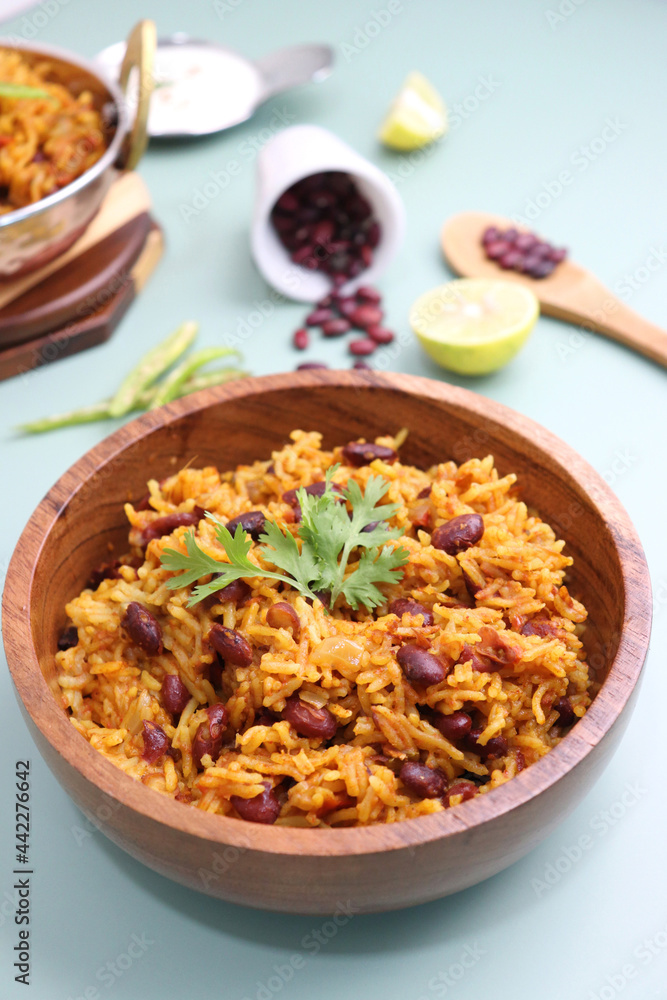 Indian cuisine - Kidney Beans Biryani, Rajma Pulao. Garnished with chopped coriander, and lemon wedges. Rajma biryani served with dahi. Along with copy space. Rajma Chawal flatlay. Indian cuisine - Kidney Beans Biryani, Rajma Pulao. Garnished with chopped coriander, and lemon wedges. Rajma biryani served with dahi. Along with copy space. Rajma Chawal flatlay.