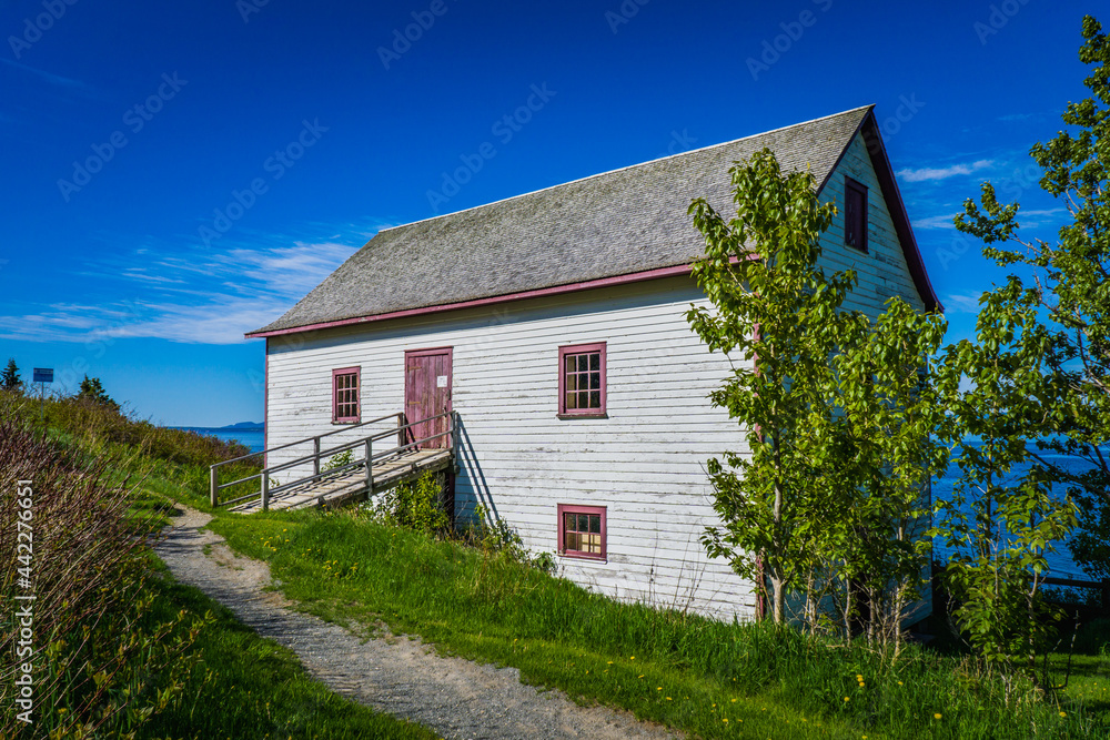 Obraz premium View on an old warehouse at Grande Grave, the starting point of Les Graves hiking trail in Gaspé, Quebec (Canada)