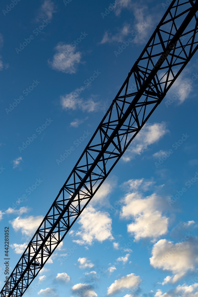 Iron part of the overall gate on the railway on a blue background with clouds vertical orientation