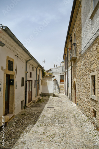 Fototapeta Naklejka Na Ścianę i Meble -  Bovino, Italy, 06/23/2021. A narrow street among the old houses of a medieval town with a Mediterranean style in the Puglia region.