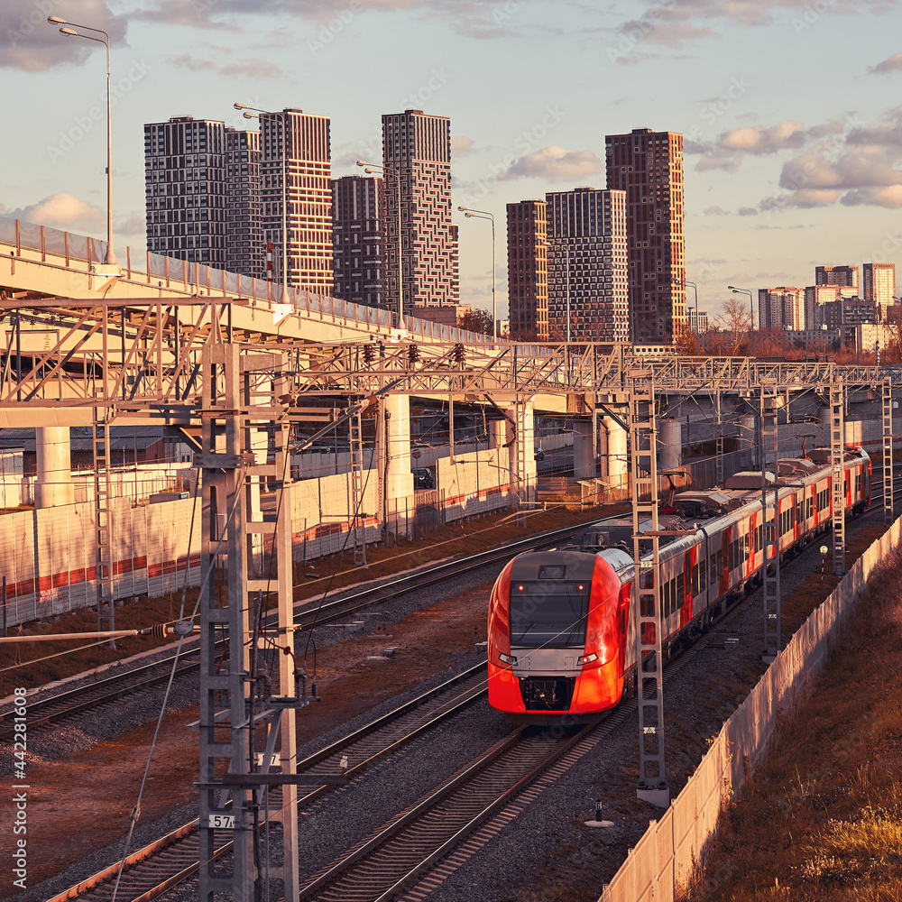 Obraz premium Modern passenger high-speed train on the background of city buildings
