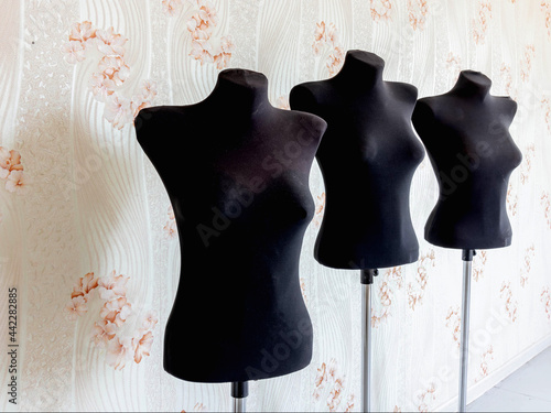 Against the wall are three black mannequins for the tailor cutter