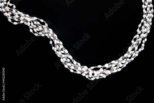 Beautiful white pearls necklace on black background.