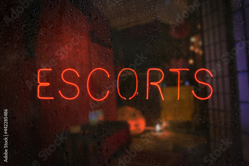 Fotografie Vintage Neon Sign in Wet Rainy Window Escorts