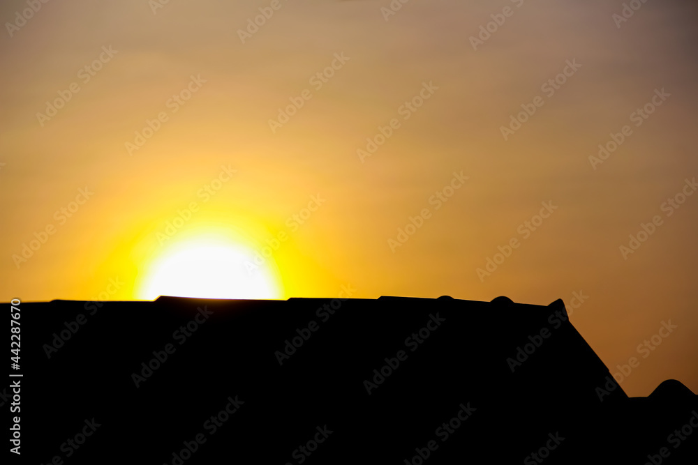 Close up sunrise and silhouette of house roof on beautiful sky background in the morning