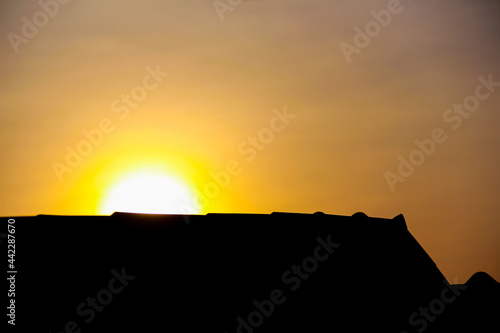 Close up sunrise and silhouette of house roof on beautiful sky background in the morning