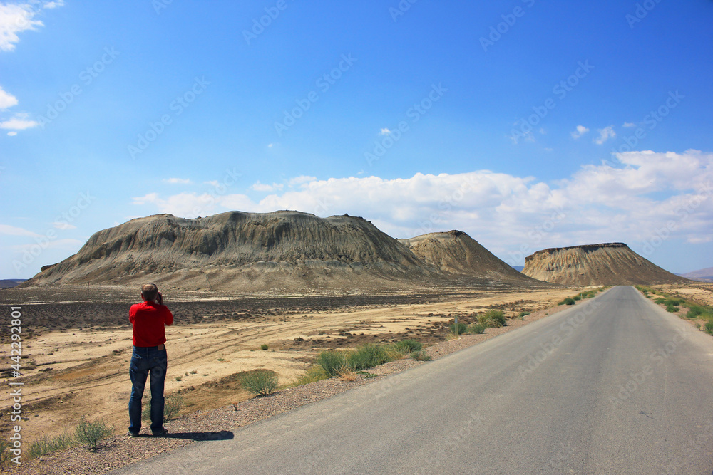 A photographer takes pictures of mountains and steppes near the town of Sangachaly. Azerbaijan.
