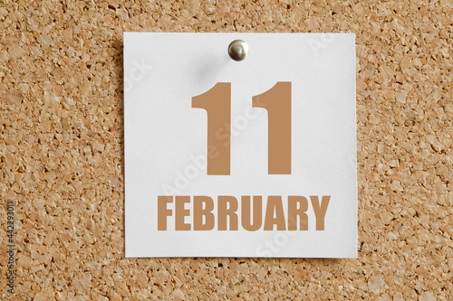 february 11. 11th day of the month, calendar date.White calendar sheet attached to brown cork board.Winter month, day of the year concept photo