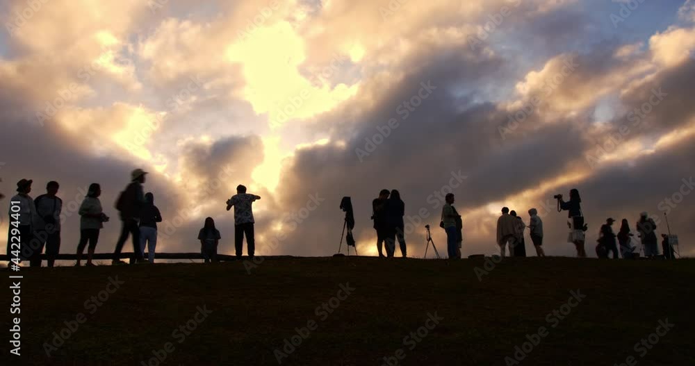 Silhouettes of tourist crowd waiting for the sunrise and doing activity, taking a photo, selfie with nature on the hill at viewpoint in time lapse shot. Silhouettes of tourist crowd waiting for the sunrise and doing activity, taking a photo, selfie with nature on the hill at viewpoint in time lapse shot.