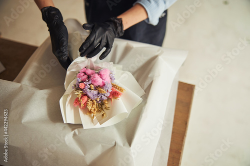 Floral arranger preparing a flower arrangement for shipping photo