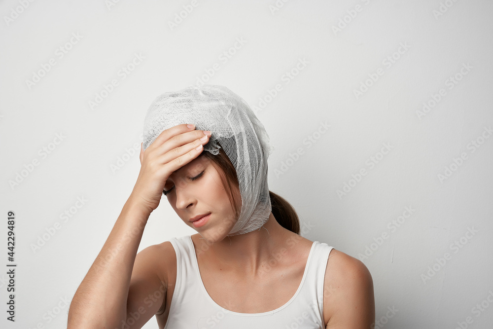 woman holding onto bandaged head injury health problems treatment woman holding onto bandaged head injury health problems treatment
