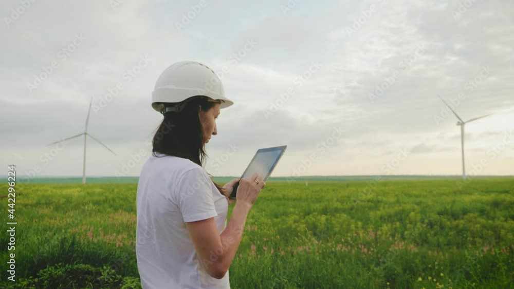 Woman engineer working in wind turbine electricity industrial at sunset. Woman engineer working in wind turbine electricity industrial at sunset.