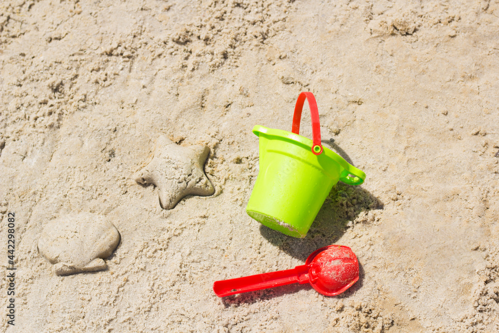 Children beach toys buckets, spade, shovel on sand. Sunny day on the seaside. Star and shell form Children beach toys buckets, spade, shovel on sand. Sunny day on the seaside. Star and shell form