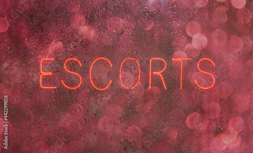 Fotografie Vintage Neon Sign in Wet Rainy Window Escorts