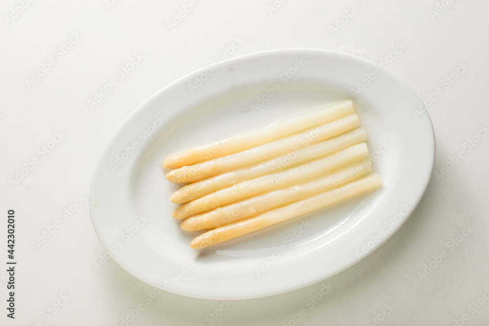 Espárragos blancos sobre plato en fondo blanco. White asparagus on plate in white background. Espárragos blancos sobre plato en fondo blanco. White asparagus on plate in white background.