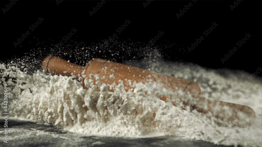 Super slow motion of the rolling pin falls on the table with flour. On a black background. Filmed on a high-speed camera at 1000 fps. Super slow motion of the rolling pin falls on the table with flour. On a black background. Filmed on a high-speed camera at 1000 fps.