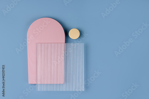 Pink arches and ribbed acrylic sheet on a blue background. Stylish background with various geometric shapes