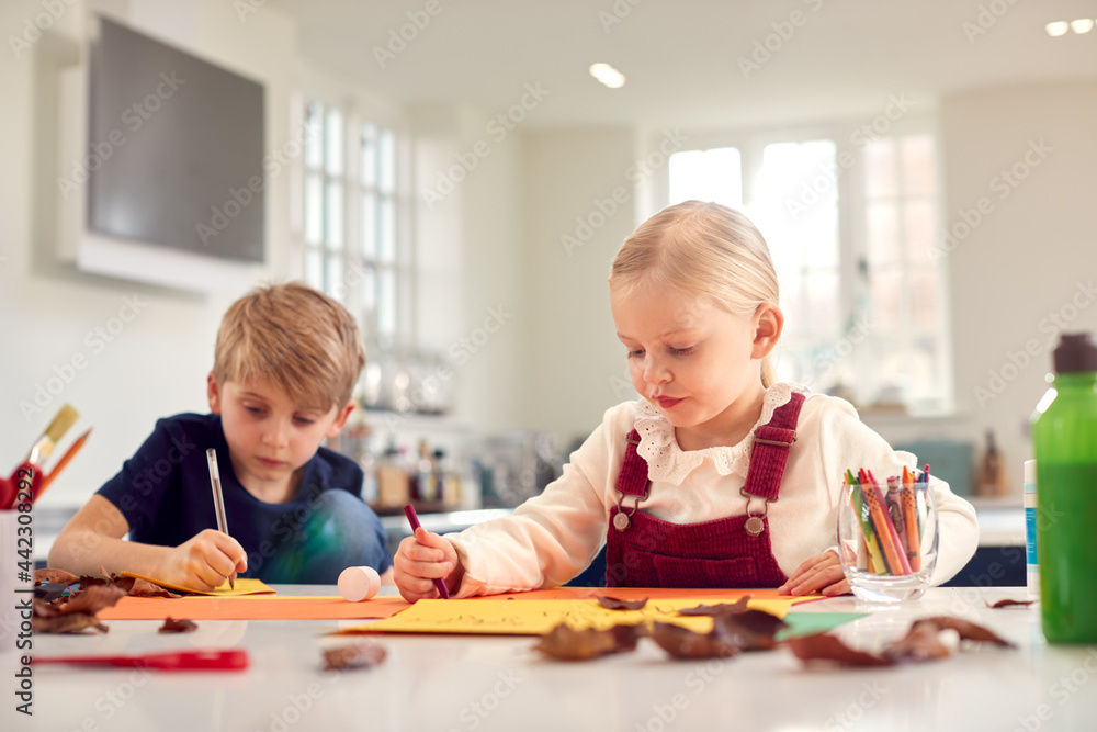Fototapeta premium Children At Home Doing Craft And Making Picture Or Card From Leaves In Kitchen