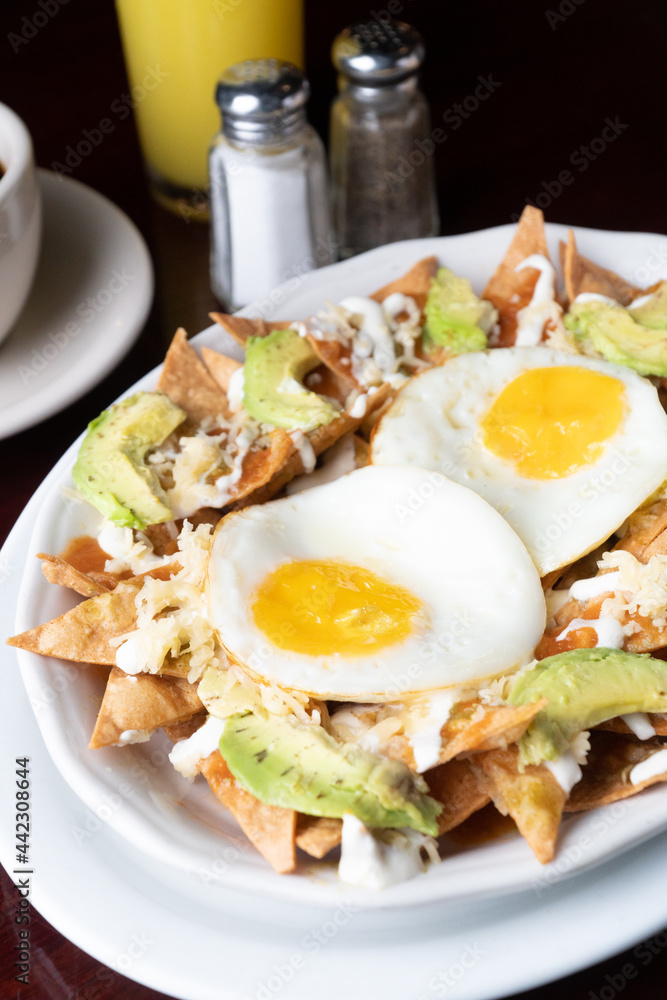 nachos with fried eggs with orange juices and coffee
