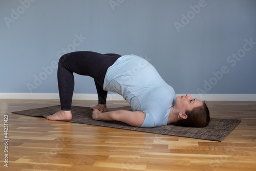 Pregnant happy fitness person enjoy yoga practice at home.