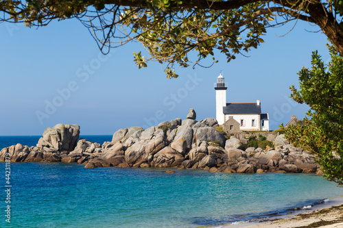 Pontusval Lighthouse on rocky shore photo