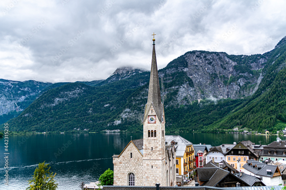 Historic Halstatt town with lake and Alps mountain at the background in Austria on a rainy summer day with overcast weather