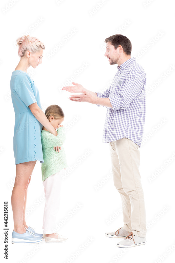 Vertical full length side view studio shot of husband and wife having conflict quarrelling, their daughter feeling sad about it, white background Vertical full length side view studio shot of husband and wife having conflict quarrelling, their daughter feeling sad about it, white background