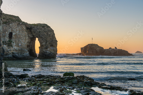 A view of the sea arch and rocky island from Perranporth beach, Cornwall