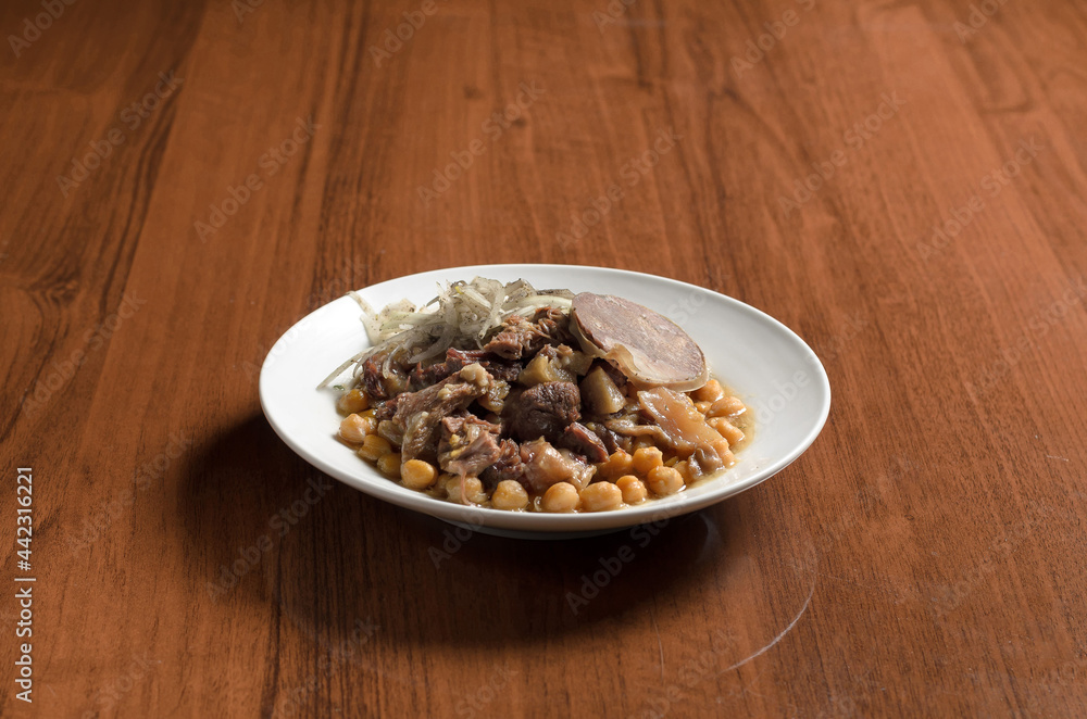 Asian cuisine Uzbek food Nukhot shurak, stewed chickpeas with meat, in a white plate with onions and horse meat sausage on the table
Asian cuisine Uzbek food Nukhot shurak, stewed chickpeas with meat, in a white plate with onions and horse meat sausage on the table