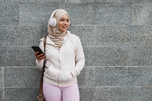 Smiling mid aged muslim woman in headphones © Drobot Dean