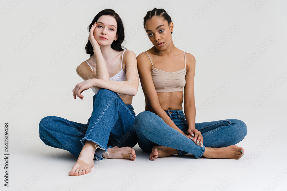 Two young diverse women posing together over Two young diverse women posing together over