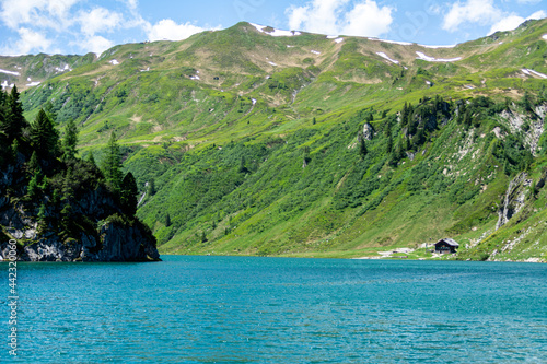 Panoramic view of the Tappenkar Lake in the Austrian Alps. Crystal clear water and surrounding mountains with meadows in Summer. Alpine Landscape