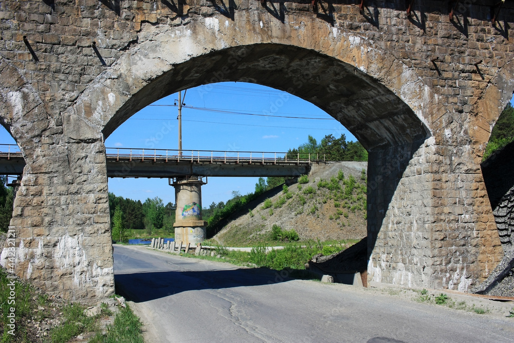 Fototapeta premium Old stone railway bridge over the road