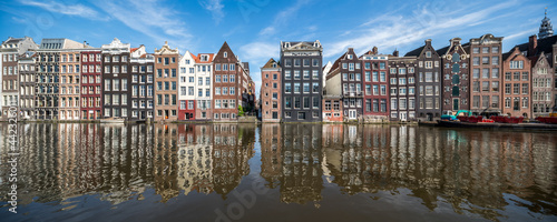 Panoramic view of traditional houses along the Damrak canal in Amsterdam, Netherlands