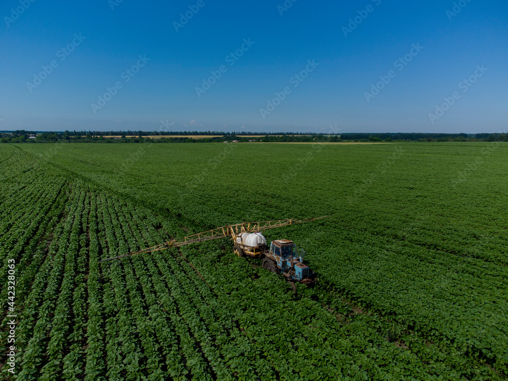 Tractor with a sprayer on a sun field. Application of herbicides. Tractor with a sprayer on a sun field. Application of herbicides.