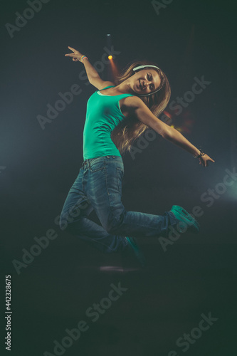Fototapeta Naklejka Na Ścianę i Meble -  Dynamic animated young woman jumping with headphones