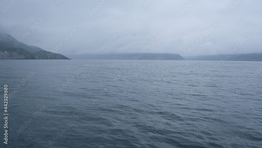 hills and mountains in big water on a gray day in the pacific ocean