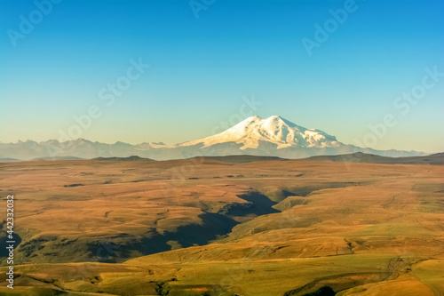 Beautiful landscape of mountain meadows in an early sunny summer morning. North Caucasus, Elbrus peaks. © Marson