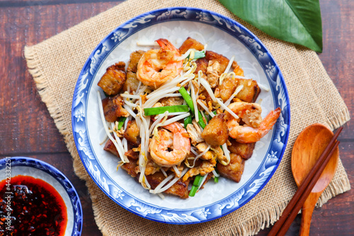 Stir fried turnip cake with shrimp, bean spout and chives with chili sauce on the side  - Chinese food called Char Koay Kak photo