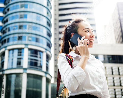 Φωτογραφία Asian businesswoman in a city on the phone