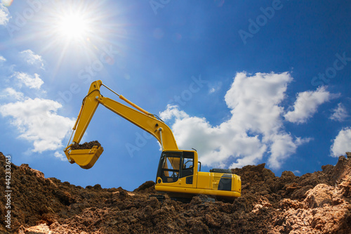 Crawler Excavator digging the soil In the construction site area with blue sky and sunlight background