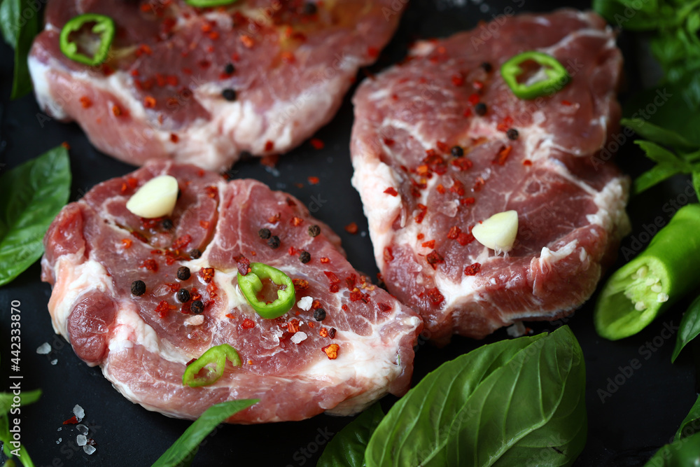 Fresh raw meat steak with spices and fresh basil. Fresh raw meat steak with spices and fresh basil.