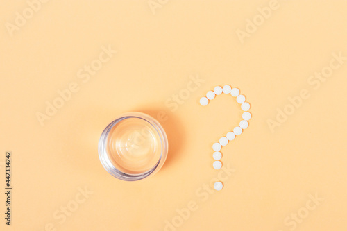 Medical pills laid out on table in form of question mark