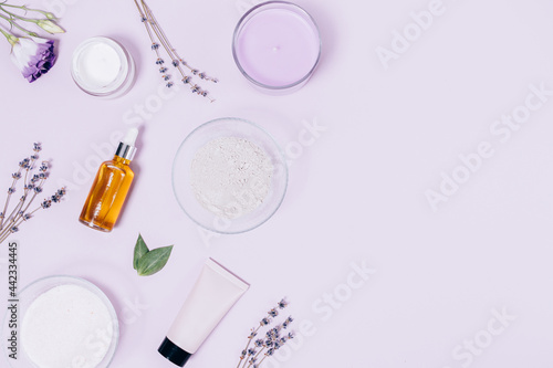 Flat composition with lavender flowers, scented candle, oil and natural cosmetics